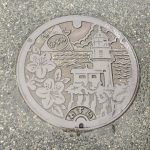 香住のマンホールの図柄は「サツキ」と「余部埼灯台」と「日本海」と「カニマーク」