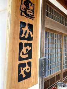 玄関かどや看板横の佐津温泉看板
