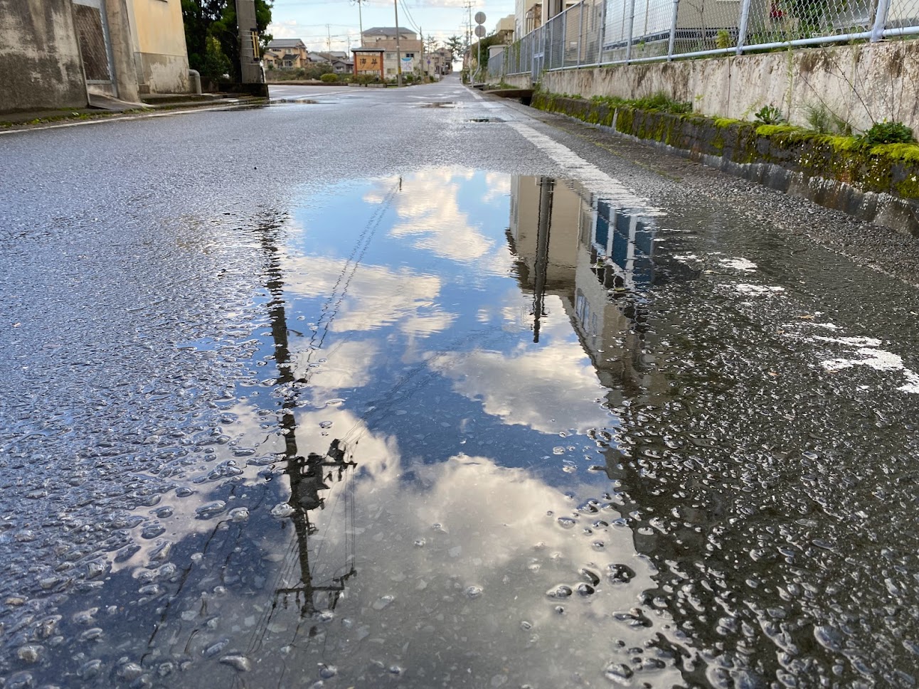 雨上がりの水たまりに映った空