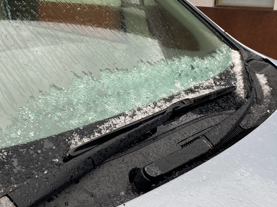車のフロントガラスにシャーベット状の雪が少しついた程度