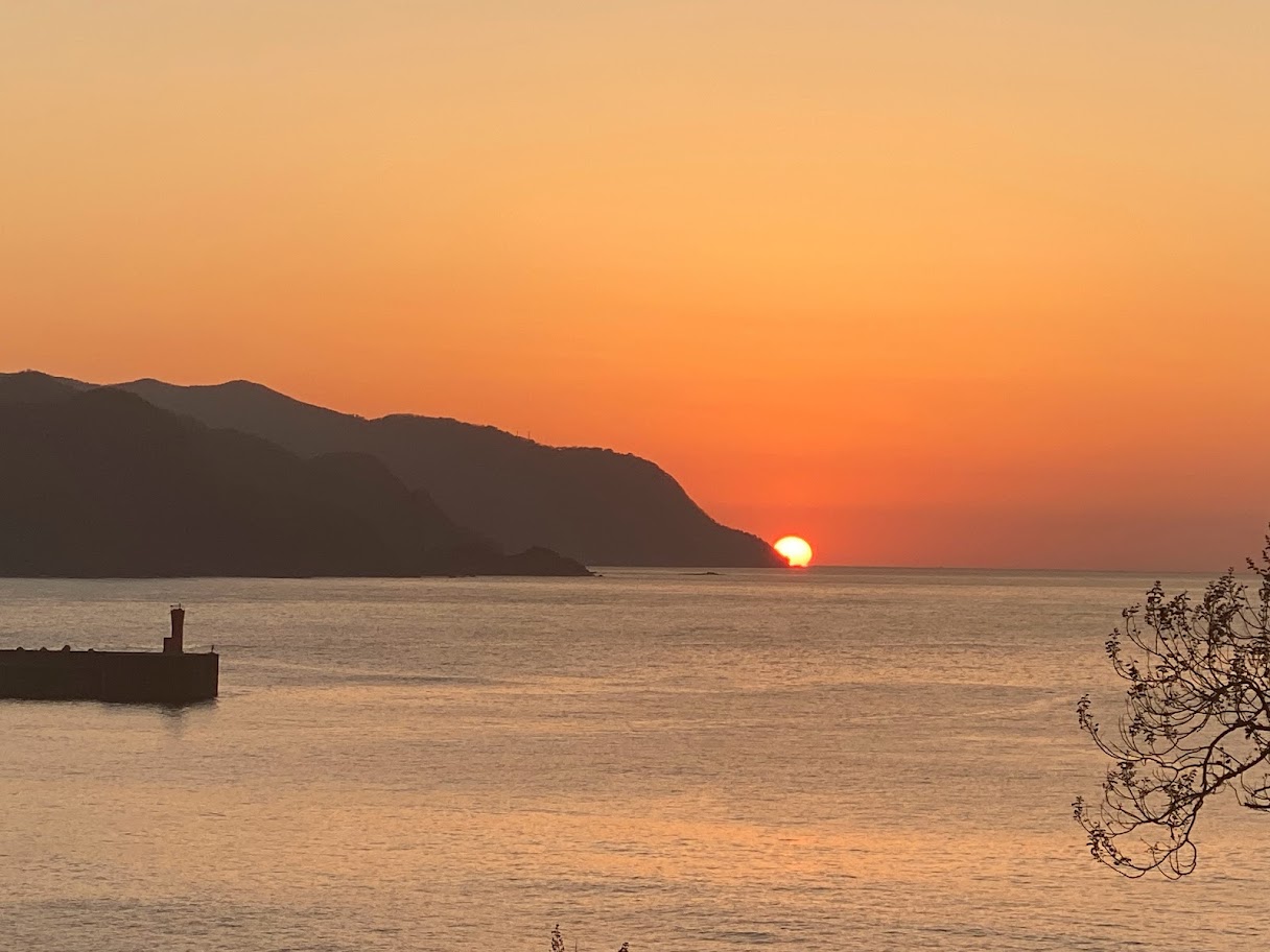 山に半分引っかかっている貴重な瞬間のタイミングの夕陽